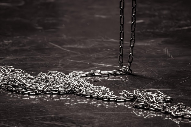 Photo iron chain on a dark background chain links solid rope steel structure sequential connection