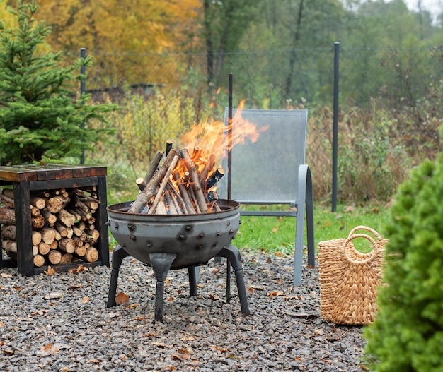 Photo iron fire pit and burning fire in a garden