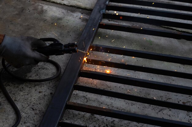 Iron gate repair, worker hand welding steel