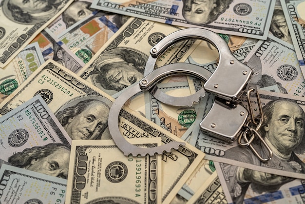 Iron handcuffs on 100 us dollar. crime concept