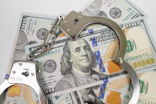 Photo iron handcuffs and 100 us dollars crime concept