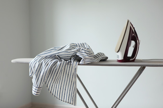 Iron and ironing board in a bright room iron clothes