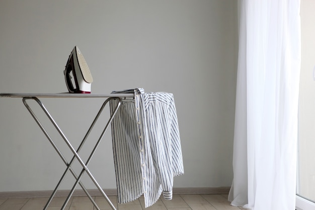 Iron and ironing board in a bright room iron clothes