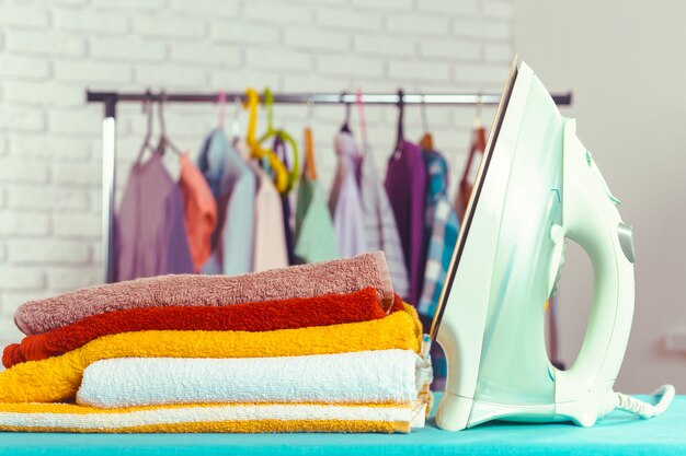 Iron on ironing board on light home interior background