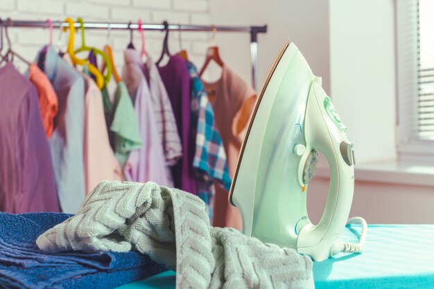 Iron on ironing board on light home interior 