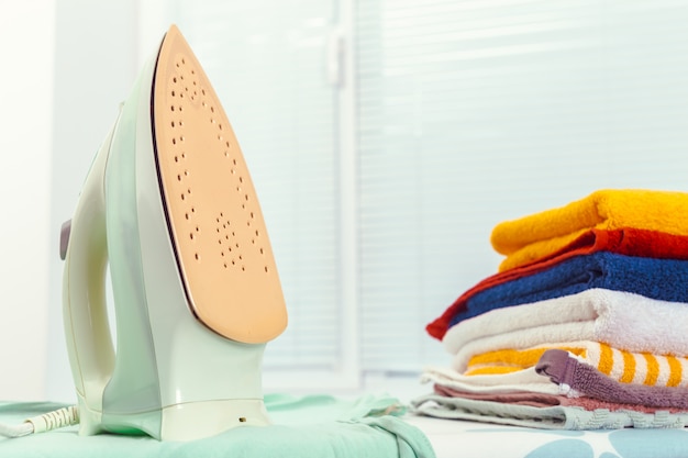 Iron on ironing board on light home interior