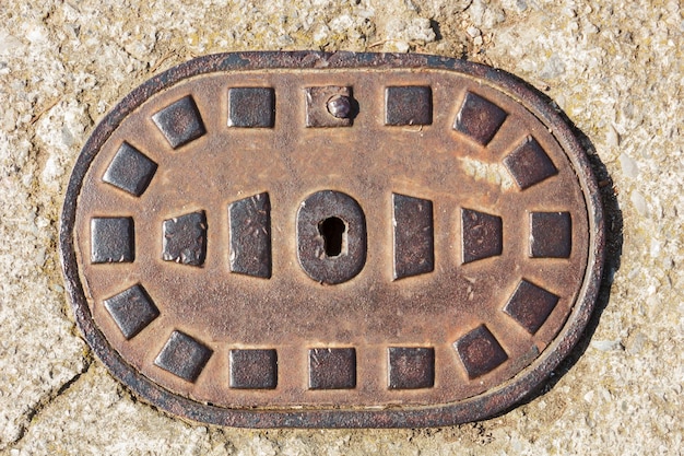 Iron manhole cover on the concrete surface