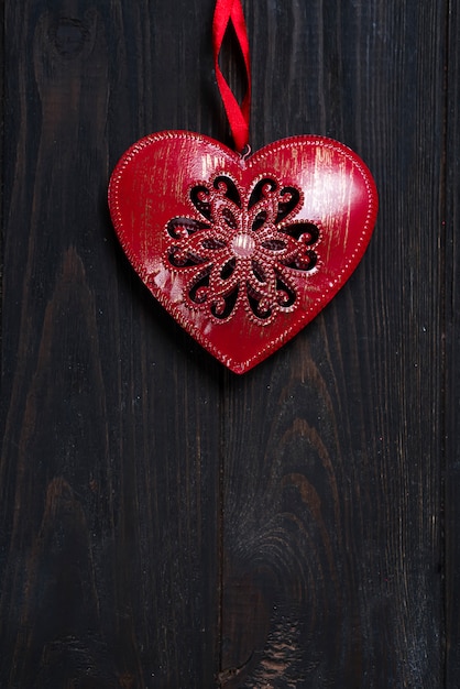 iron red heart on wooden background.