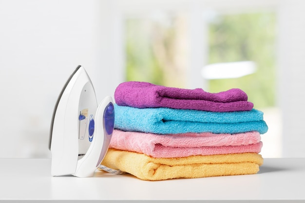 Iron and towels on white desk