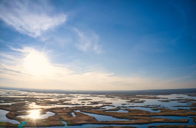夕方の暖かい明るい光の中でウクライナのドニエプル川のサマラ川にたまらない洪水。空中パノラマドローンショット