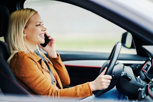 An irresponsible driver is driving her car while talking on the phone