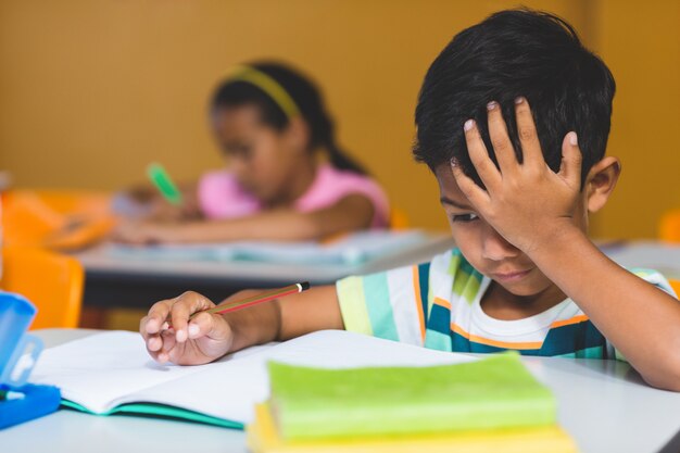 本を見て手に頭を持つイライラ少年