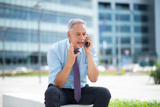 Photo irritated man talking on the cellphone