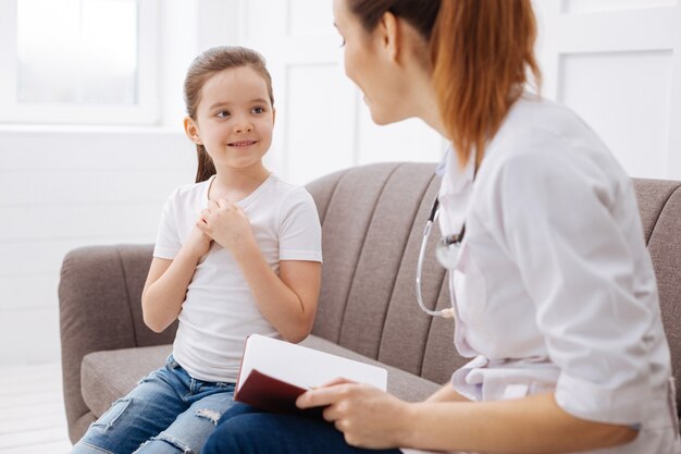 Is this all right. Two charming clever ladies having girls talk while sitting on the couch and discussing health together