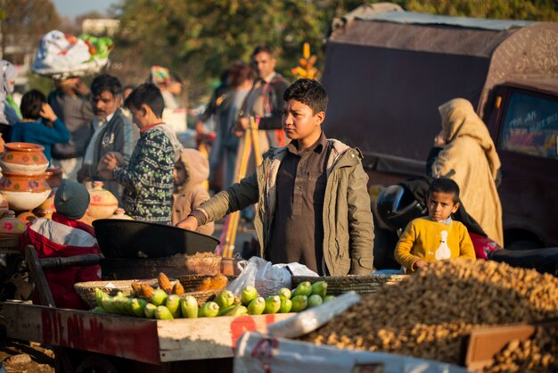 Islamabad, islamabad capital territory, pakistan - 5 febbraio 2020, un ragazzo sta arrostendo mais fresco per i clienti.