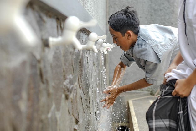 A islamic boarding school student is doing ablution washing his hand