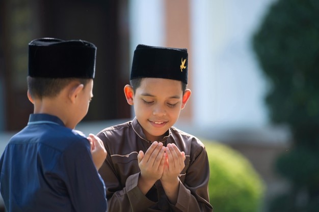 Foto un bambino islamico prega per studiare con sua sorella e suo fratello in una moschea a songkhla, in thailandia.