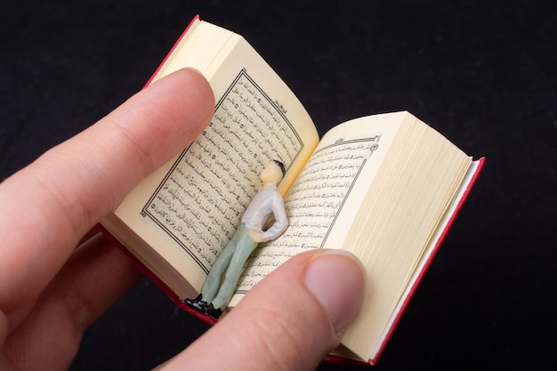 Photo islamic holy book quran with figurine in hand