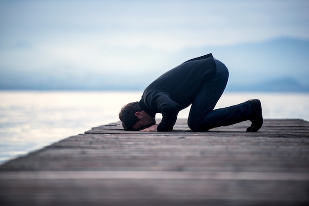 Islamic man praying on pier