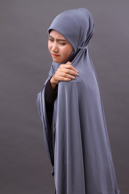 Islamic muslim woman with shoulder or neck pain, stiffness, injury