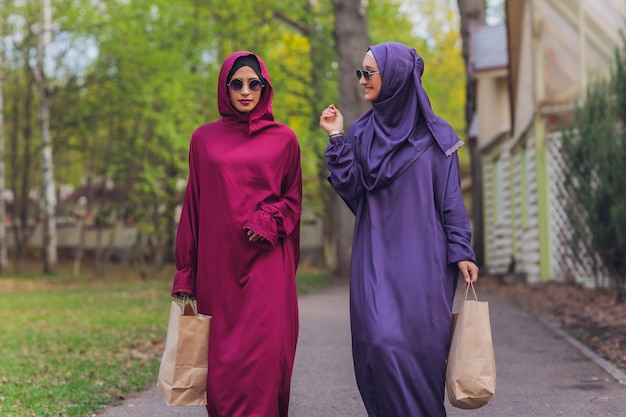 Islamitische mooie vrouw in een moslim jurk staande op een zomer park straat achtergrond bos herfst bomen. wereld hijab dag.