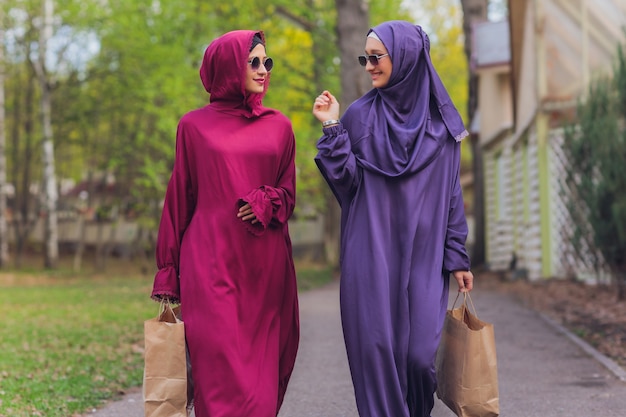 Islamitische mooie vrouw in een moslim jurk staande op een zomer park straat achtergrond bos herfst bomen. wereld hijab dag.