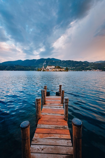 Foto l'isola di san giulio con un molo di legno in primo piano al tramonto