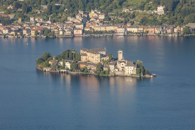 이탈리아 소모 호수의 푸른 바다 위에 고대 주택이 있는 섬