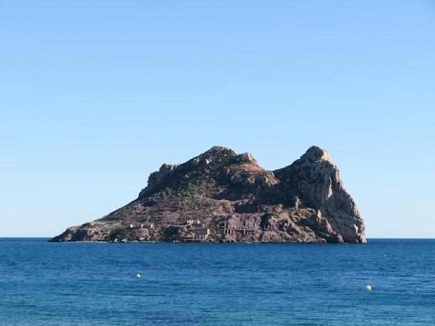 緑の木々と青いマスに囲まれた廃屋のある島