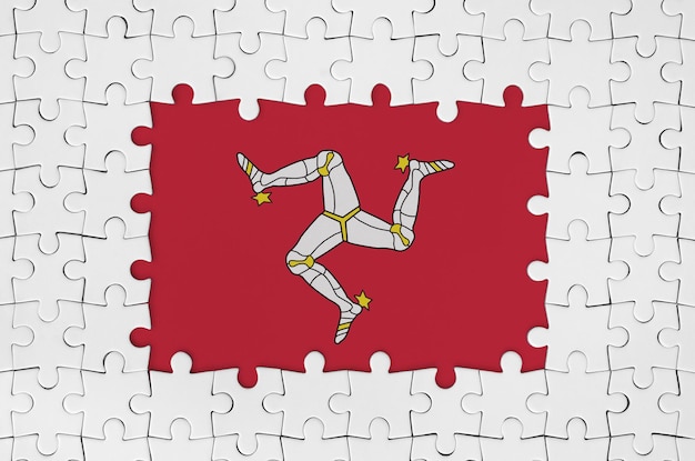 Foto bandiera dell'isola di man in cornice di pezzi di puzzle bianchi con parte centrale mancante