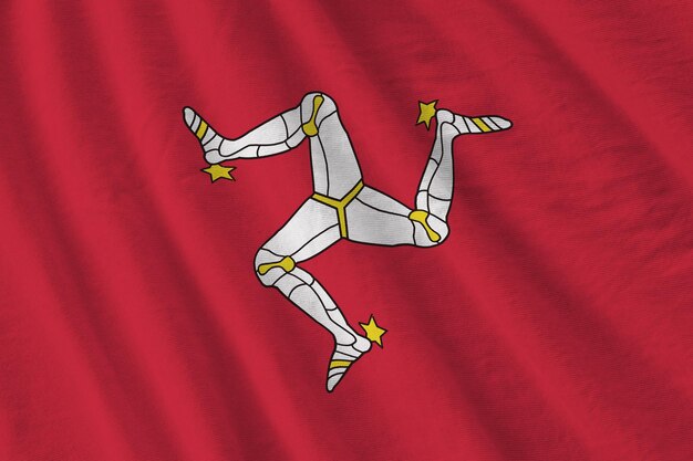 Isle of Man-vlag met grote plooien die van dichtbij zwaaien onder het studiolicht binnenshuis De officiële symbolen en kleuren in banner