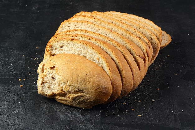 Isolate of white loaf of bread with sliced pieces on a black background