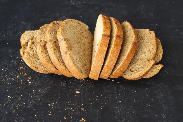 Isolate of white loaf of bread with sliced pieces on a black background