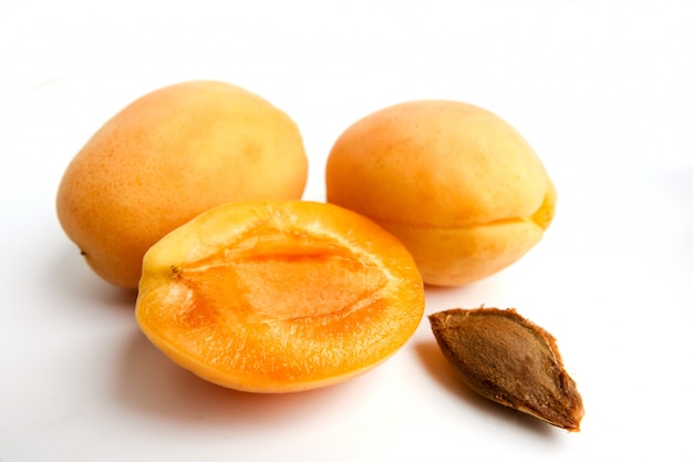 Изолированные абрикосы. Свежий весь абрикосовый фрукт с листьев и половина на белом фоне с отсечения путь