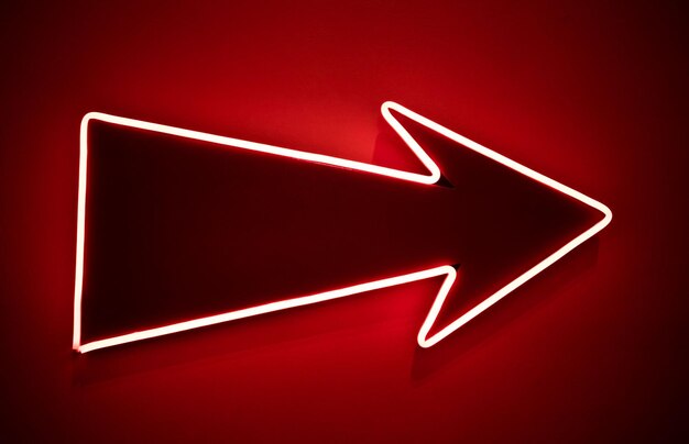 Photo isolated arrow with neon outline glowing on red background