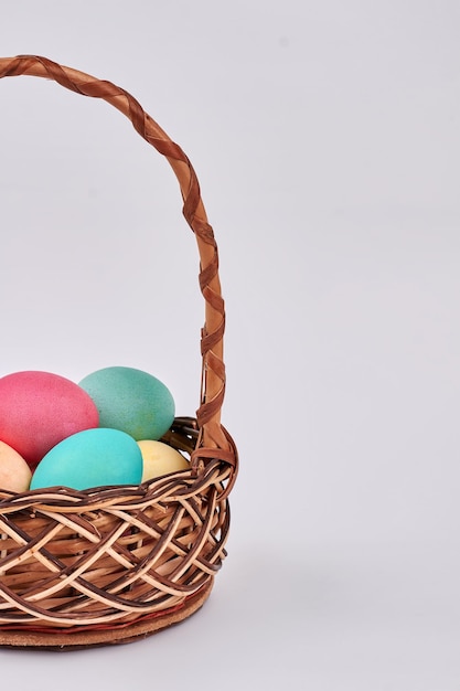 Isolated basket with colored eggs Easter wicker basket