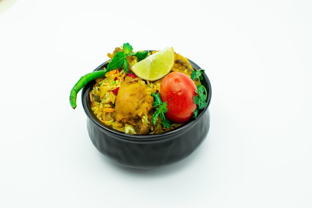 Isolated delicious spicy chicken biryani in black bowl on white background