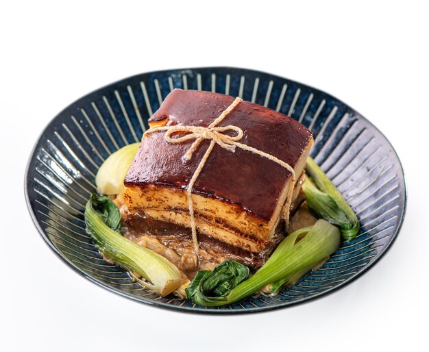 Isolated Dong Po Rou Dongpo pork meat in a beautiful plate with green vegetable