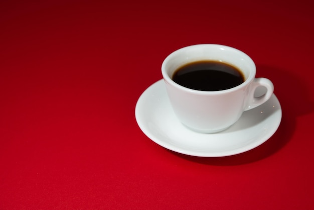 isolated espresso in a white cup on red background copy space