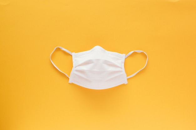 Isolated face mask in the middle on a yellow background