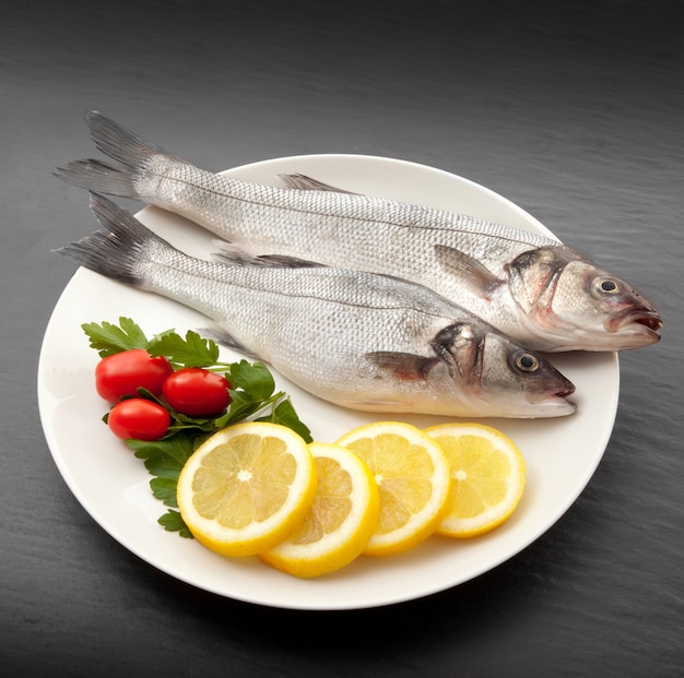 Isolated fresh bass dish in stone background