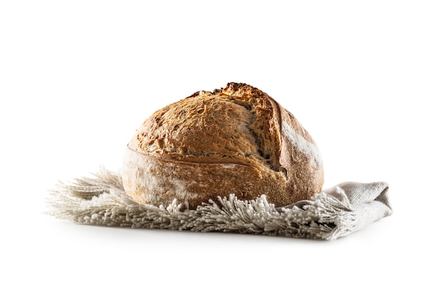 Фото Изолированные свежеиспеченный хрустящий буханка дрожжевого хлеба, лежащая на льняной посуде.