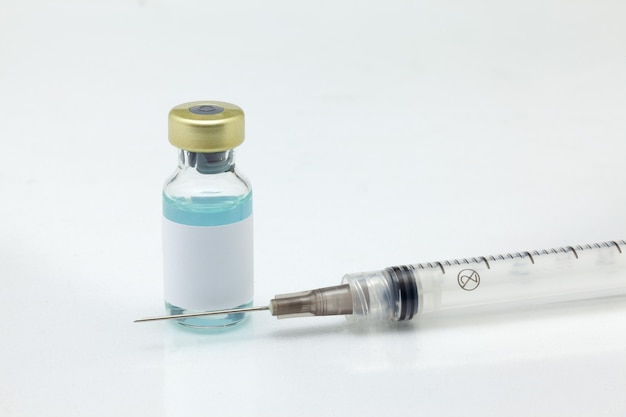 Photo isolated glass vaccine bottle with colored liquid and syringe very close high magnification mockup