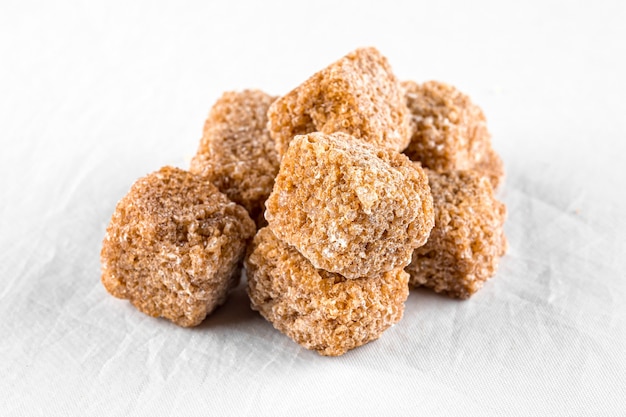 Isolated handful of brown cane sugar cubes