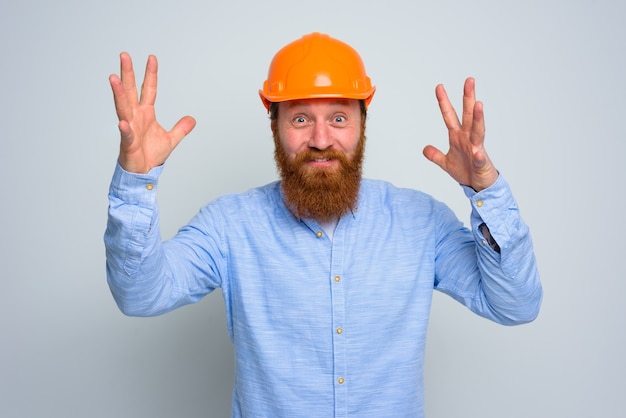 Isolated happy architect with beard and orange helmet