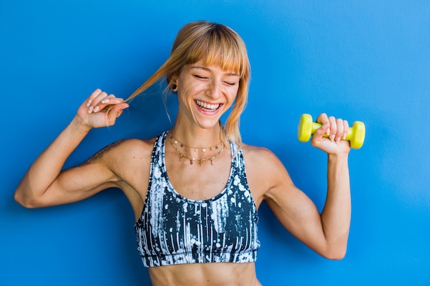 Isolated happy athletic young woman on a blue background