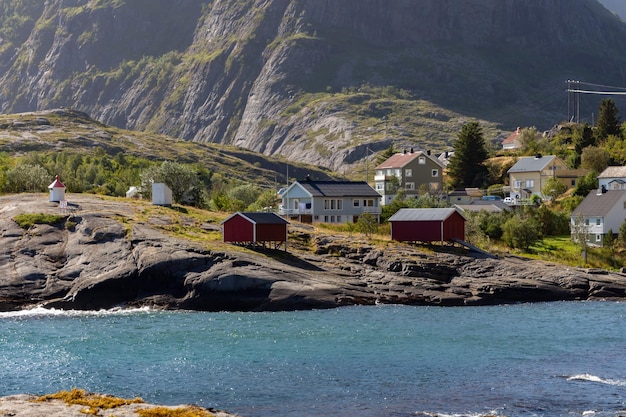 Isolated houses on the seashore with rocks and mountains in the background