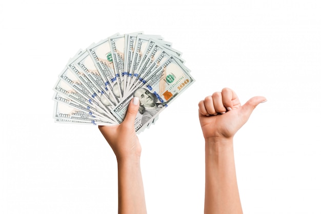 Isolated image of dollars in one hand and showing thumb up gesture with another hand. Top view of business concept