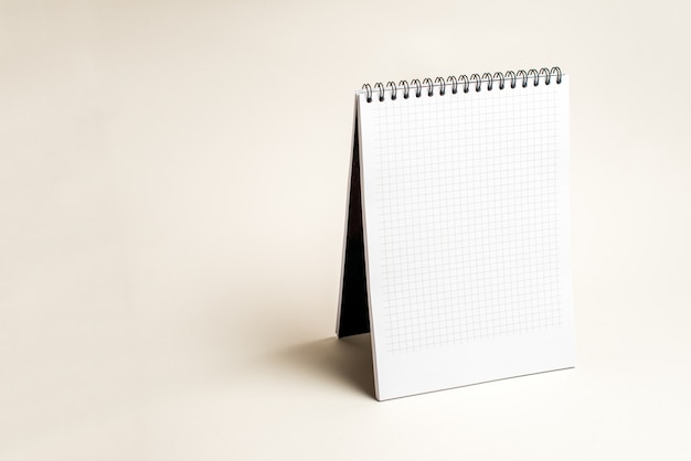 Isolated notebook with spiral on the light brown background