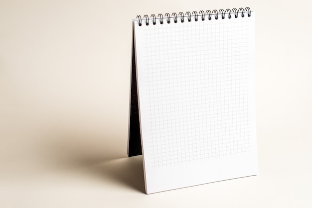 Isolated notebook with spiral on the light brown background